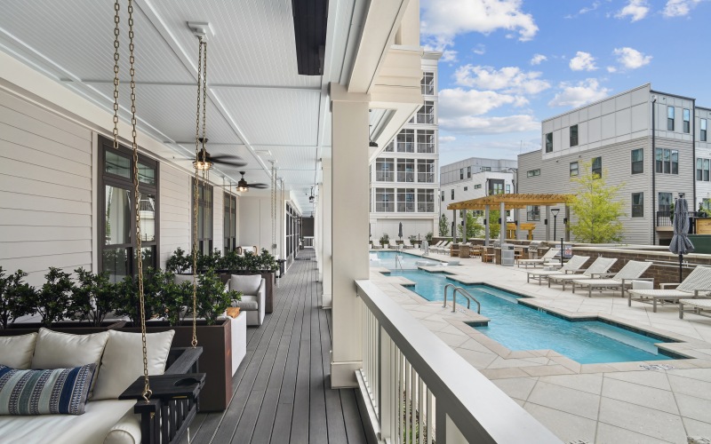 Hanging couches on a porch next to a pool