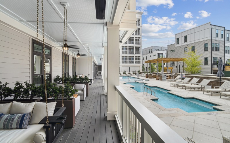 Hanging couches on a porch next to a pool