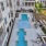  A large swimming pool surrounded by an apartment building and a patio.